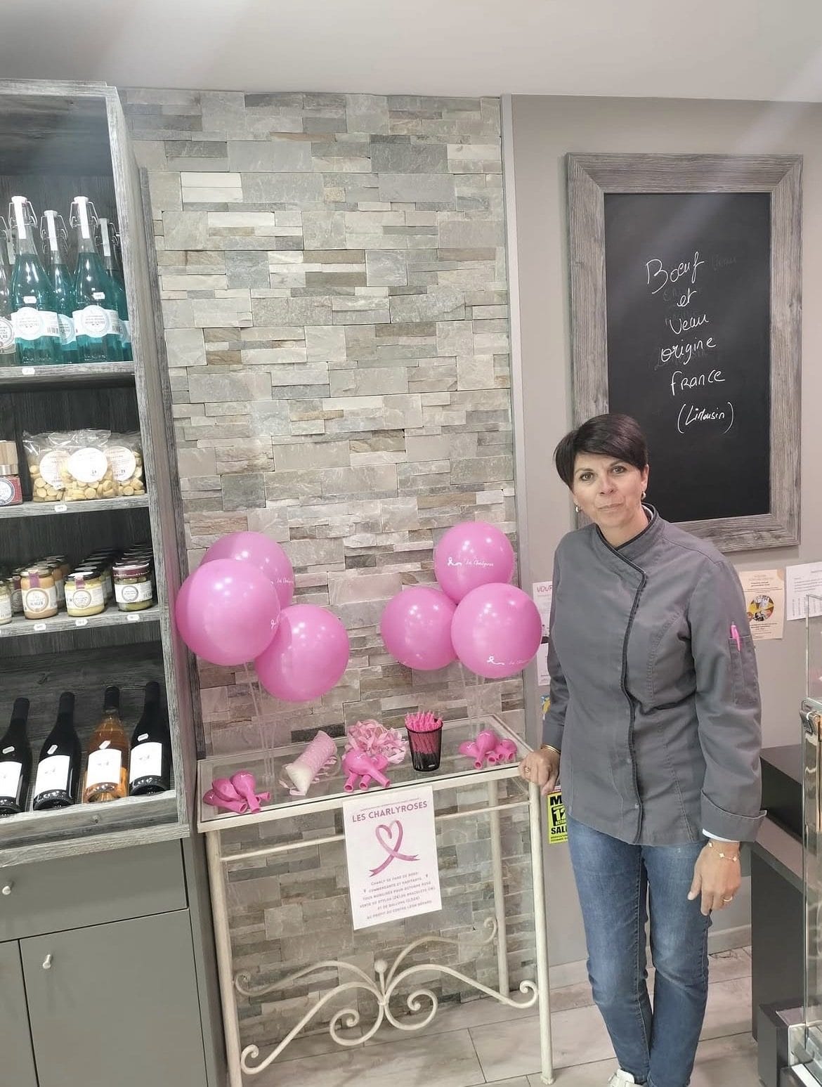 Une bouchère de La Galerie des Gourmets dans la boutique, devant l'ardoise indiquant bœuf et veau d'origine France