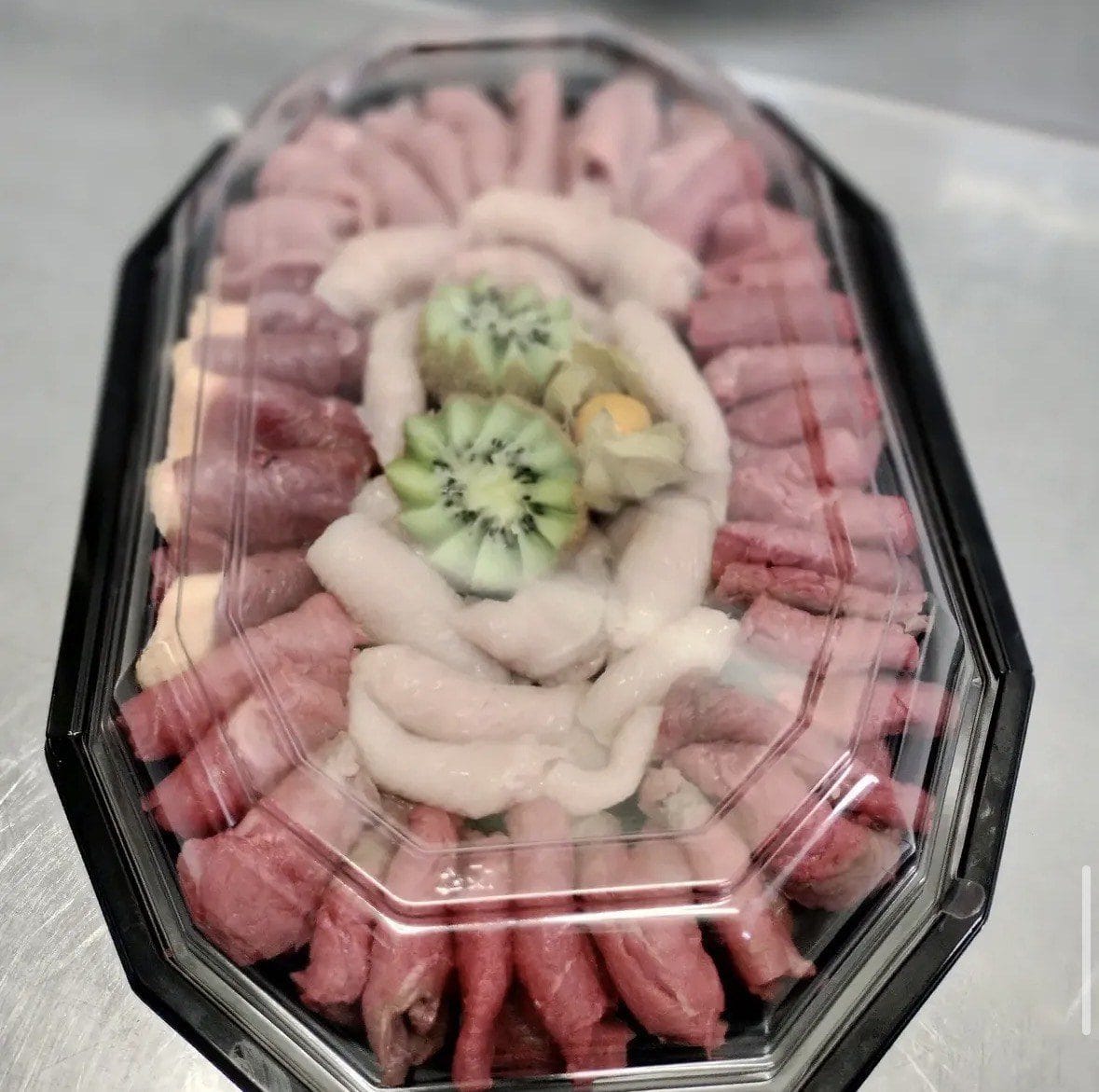 Plateau de viandes crues préparé pour une soirée : brochettes, saucisses blanches et morceaux à griller
