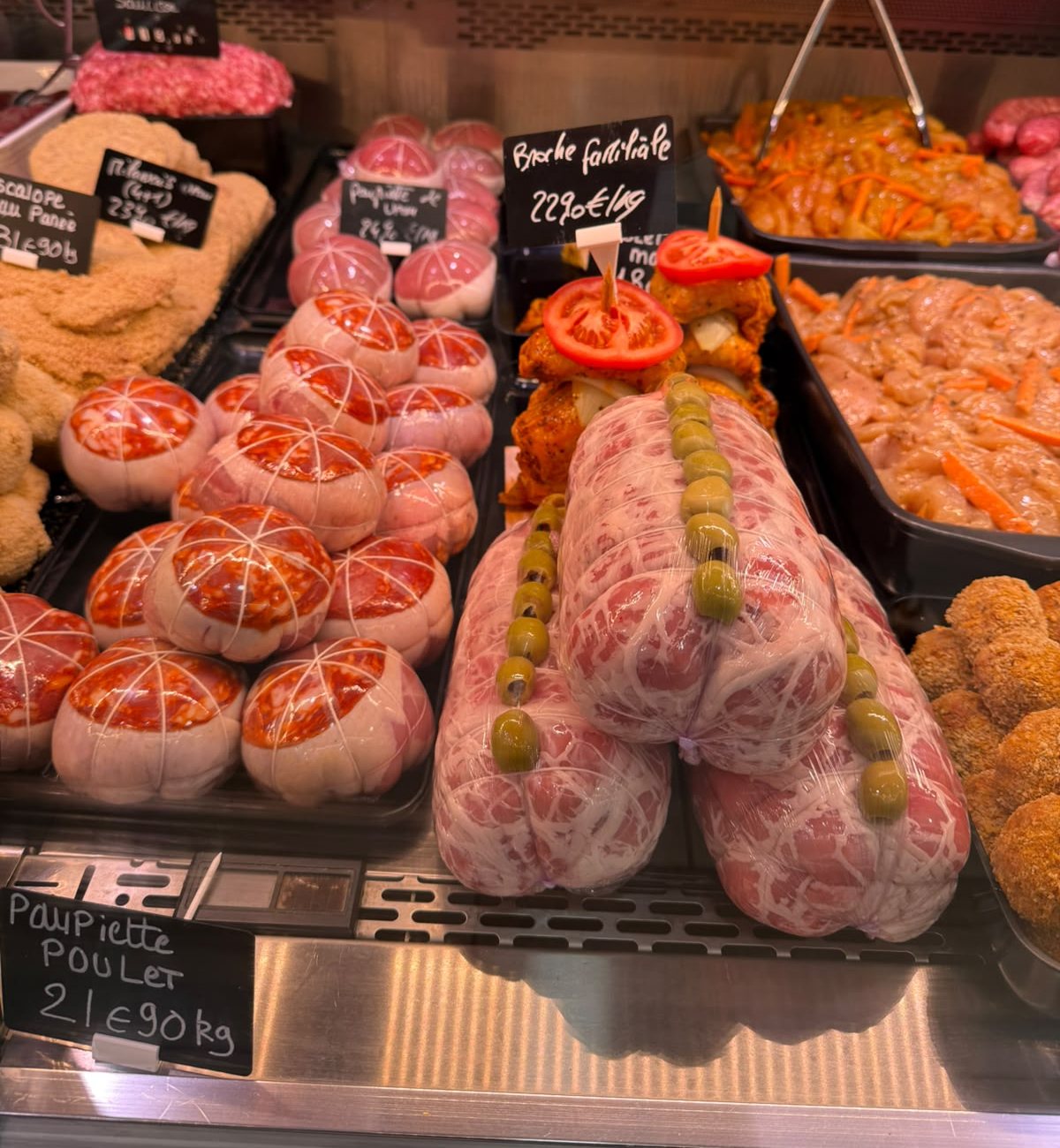 Vitrine de la boucherie : paupiettes ficelées, rôtis farcis aux olives et brochettes de volaille marinées